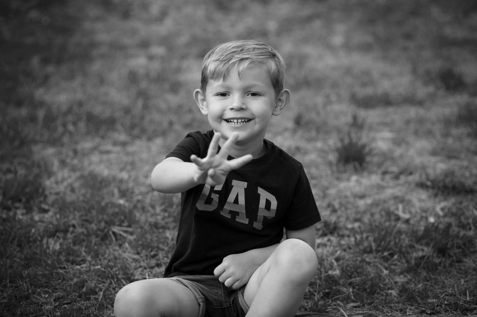 niño sonriendo en blanco y negro durante sesión de fotos familiar en Zaragoza