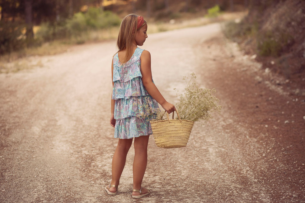niña caminando por camino rural durante sesión de fotos familiar en Zaragoza con luz natural