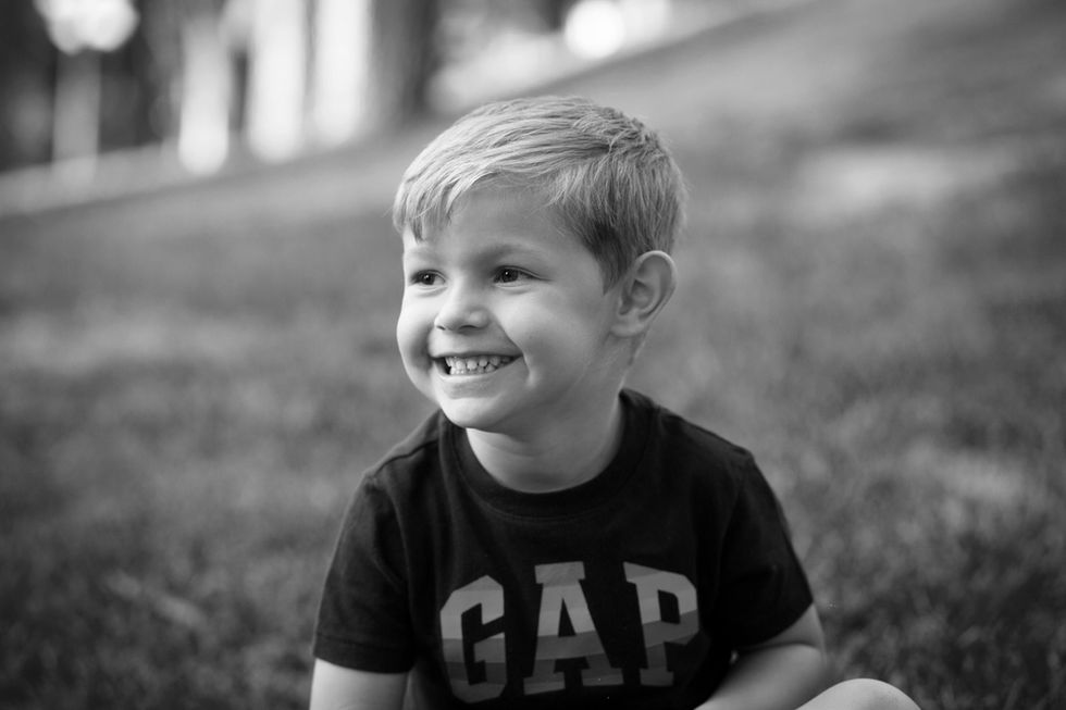 niño sonriendo en blanco y negro en sesión de fotos familiar en Zaragoza al aire libre