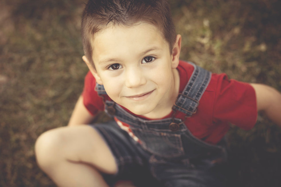 retrato de niño sonriendo en sesión de fotos familiar en Zaragoza en entorno natural