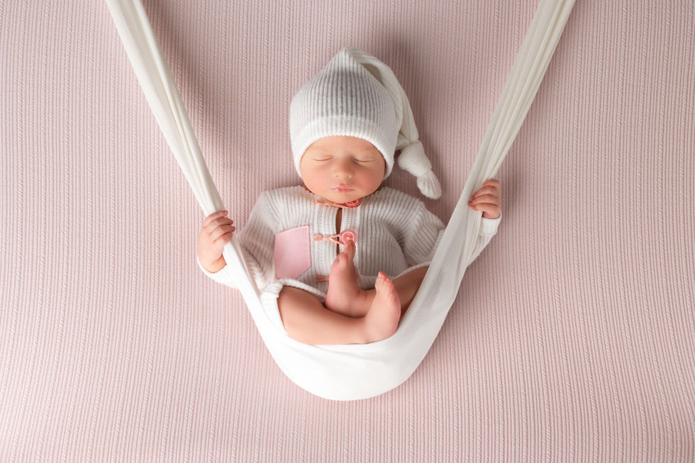Sesión newborn en Valdespartera Zaragoza con bebé recién nacido en hamaca de tela rosa
