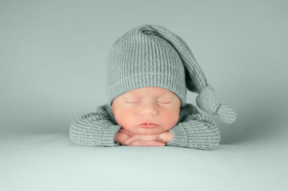 Fotografía newborn en Zaragoza de bebé recién nacido dormido con gorro gris en estudio
