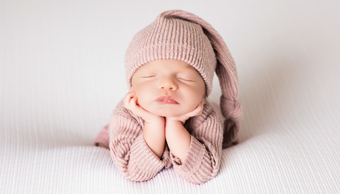 Fotógrafo newborn en Zaragoza – bebé recién nacido dormido con gorrito en sesión profesional