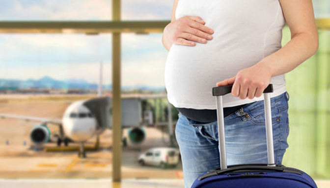 Mujer embarazada viajando en avión con una maleta antes del nacimiento de su bebé
